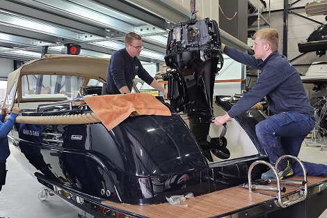 De eigenaren van Watersportkrimpenerwaard sleutelend aan een boot met motor erachter